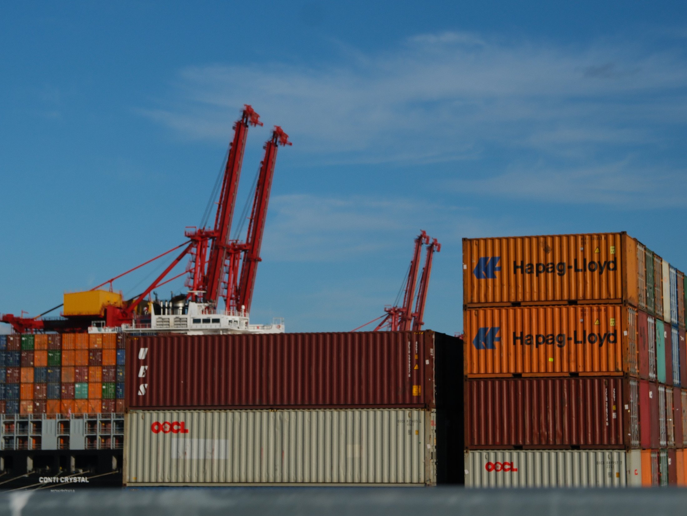 Stacked shipping containers and port cranes